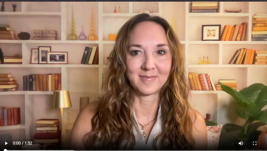 A woman with long wavy light brown hair is shown in a video call setup, positioned in front of a bookshelf background.
